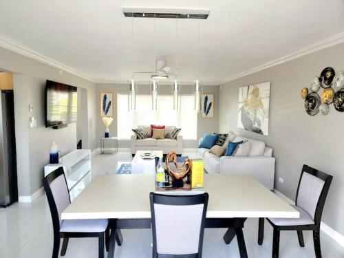 尼格瑞尔Brand New Luxurious Townhouse in Negril的客厅配有2张白色的桌子和椅子