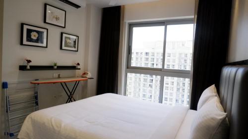 孟买RELOhomes Serviced Apartment的卧室配有白色的床和窗户。