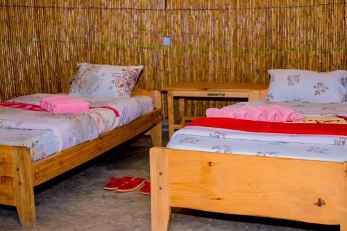 GabegiKitabi EcoCenter的配有两张床铺的客房,地板上配有拖鞋