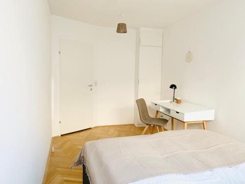 维也纳Ruhige Wohnung im Gasometer Wien *WIFI*U3*Netflix*的白色的客房配有一张床和一张书桌