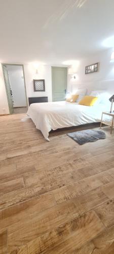 科利尤尔appart central et son parking privatif gratuit的一间卧室设有一张大床,铺有木地板