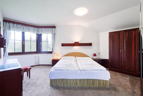 上贝奇瓦Chalupy Na Rališce的一间卧室设有一张床和两个窗户。