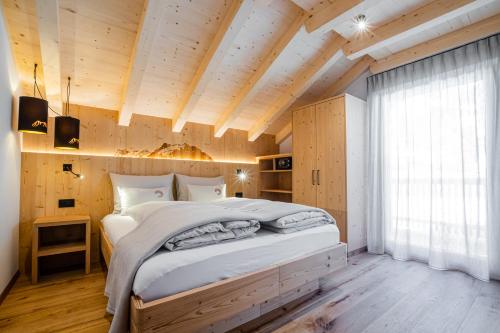 圣卡夏诺Bio Lüch Ruances的一间带一张大床的卧室,位于一个拥有木制天花板的房间