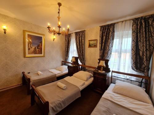 克沃兹科Pałac Ławica的酒店客房设有四张床和吊灯。