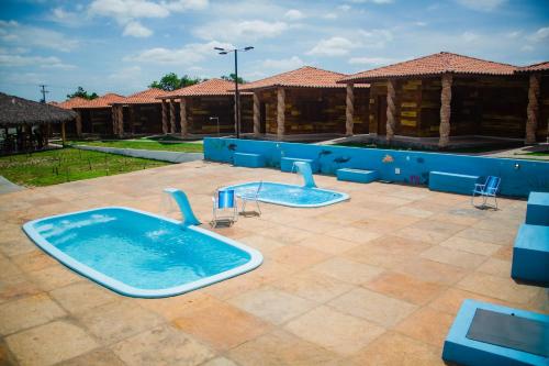 巴雷里尼亚斯Chalés Passagem do Canto的两座热水浴缸位于带大楼的庭院内