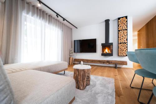 克拉尼斯卡戈拉Bor in Bor Luxury Apartment with sauna & garden - Kranjska Gora的带沙发和壁炉的客厅