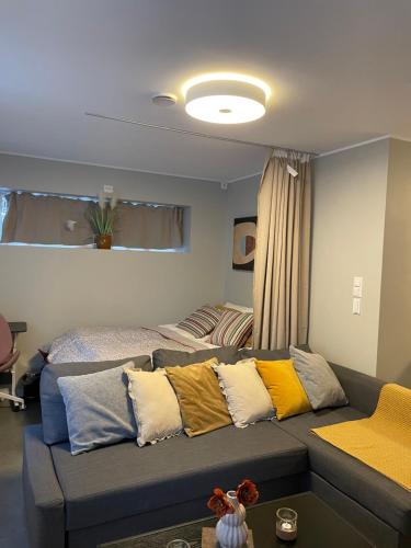莫斯Ny Hybel leilighet med eget bad og egen inngang的客厅配有带色彩缤纷枕头的沙发