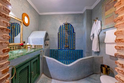 马拉喀什Maïpa Boutique Riad的一间带大浴缸和水槽的浴室