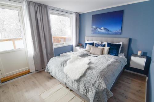 ÅmotHaugetuft Apartments的一间卧室配有一张蓝色墙壁和窗户的床