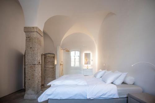 Habay-la-NeuveChâteau du Pont d'Oye的白色卧室配有一张带白色枕头的大床