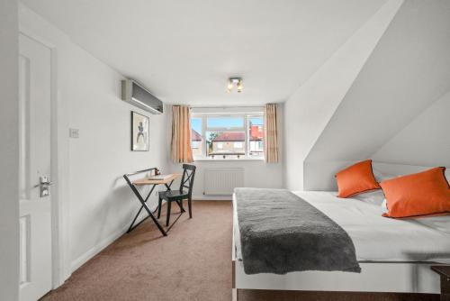伦敦Park Royal Hububb Stay的一间卧室配有一张床、一张书桌和一个窗户。
