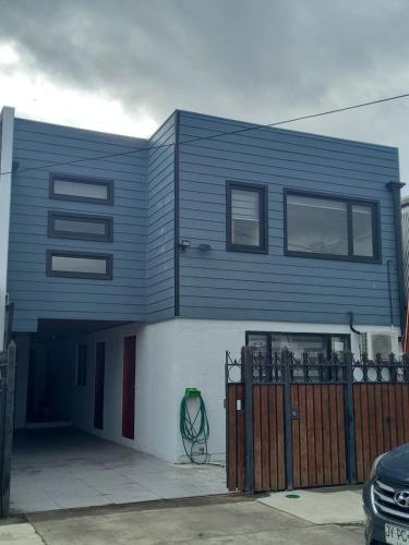 特木科Cabañas y Departamentos Las Palmas, Temuco Depto 1的前面有栅栏的蓝色房子