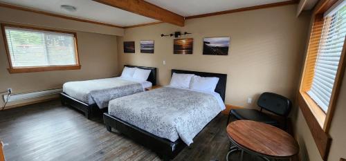 托菲诺Meares Vista Inn的酒店客房设有两张床和一张桌子。