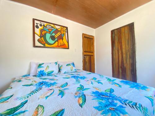 巴伊亚福尔莫萨Verano House BF的一间卧室配有一张带蓝色棉被的床
