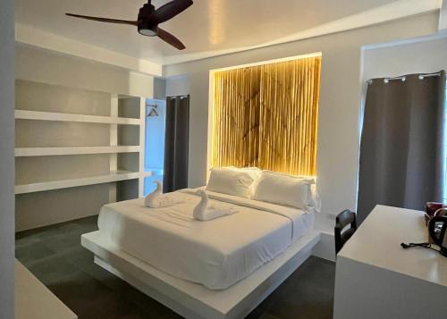 邦劳Bathala Resort的卧室配有白色的床和窗户。