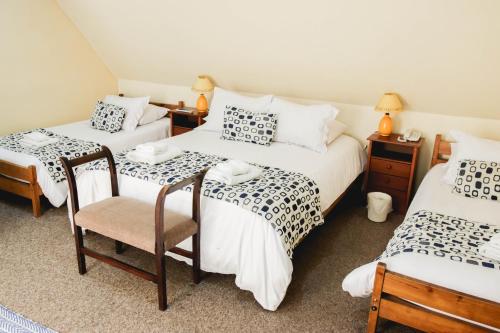 维纳德马Hotel Rondó的一间设有两张床和两把椅子的房间