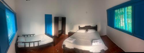 帕洛米诺Finca del Rio Palomino的一间卧室设有两张床和两个窗户。