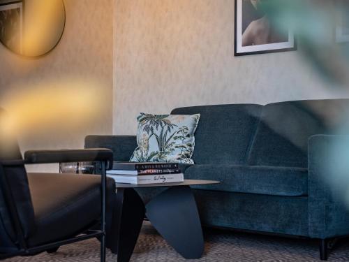 特隆赫姆Quality Hotel Prinsen的客厅配有蓝色的沙发和桌子