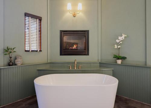 惠提尔Outland Chalet & Suites Great Smoky Mountains的带浴缸的浴室,配有壁炉