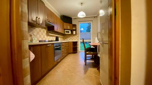 克拉科夫Dorothy的厨房配有木制橱柜和桌子。