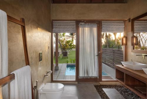 瓦都瓦Ayana Sea的一间带卫生间、水槽和镜子的浴室