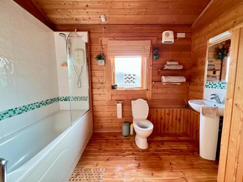 南塞尔尼Lake Pochard, Oak Lodge的浴室配有卫生间、浴缸和水槽。