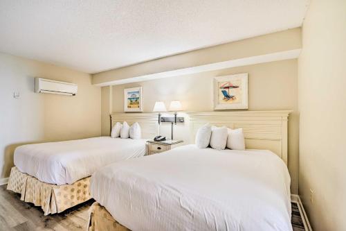 默特尔比奇Oceanfront Myrtle Beach Condo with Balcony!的配有白色床单的酒店客房内的两张床