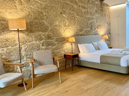 Vale de PrazeresQuinta da Porta - Solar de Vale de Prazeres的一间卧室设有一张床和石墙
