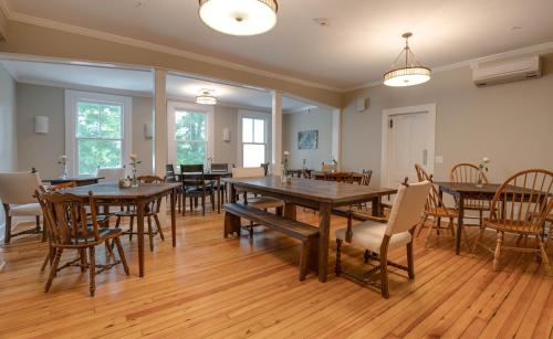 李城Lakehouse Inn的大型用餐室配有木桌和椅子