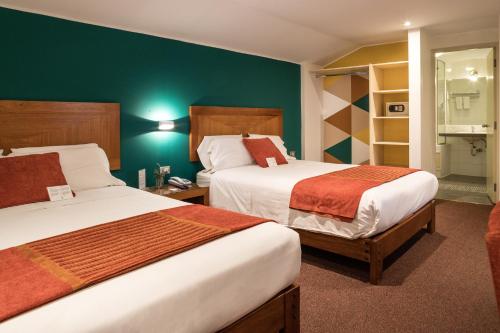 库斯科梅塔克瓦辛精品酒店的绿墙旅馆客房的两张床