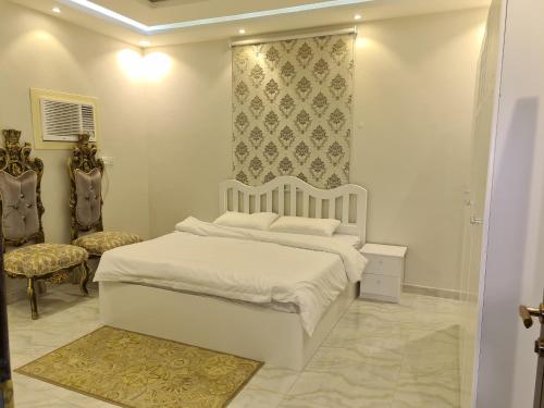阿哈达فيلا ميسرة الهدا的白色卧室配有床和椅子