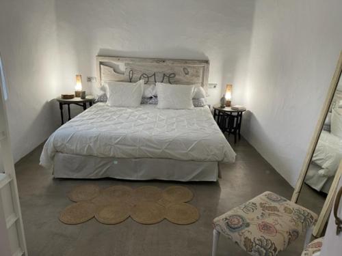 瓜蒂萨PETITE CASA LEONCIA的一间卧室配有一张带两张桌子和两盏灯的床。