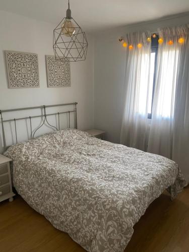 Pinilla del ValleEncanto - Pinilla del Valle的一间卧室配有床和带窗帘的窗户