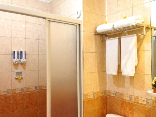 雅加达拉瓦林套房公寓酒店的带淋浴、卫生间和毛巾的浴室