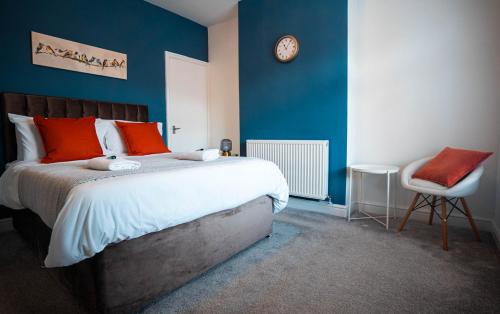 纽尼顿Comfortable equipped House in Nuneaton sleeps5 with FREE parking的卧室配有一张床,墙上挂着一个钟