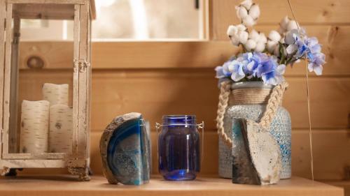 达克科里克村Charming Blue Farmhouse Cabin的一张带花瓶和镜子的桌子和一个花瓶