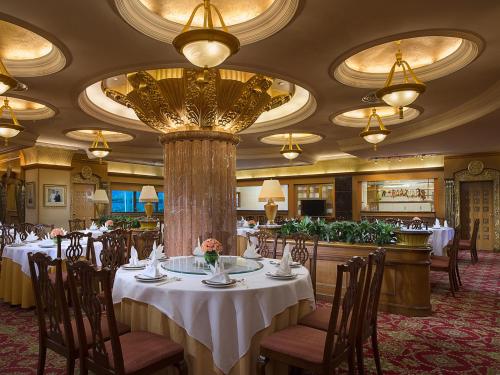 北京名人国际大酒店的一间带桌椅和大吊灯的餐厅