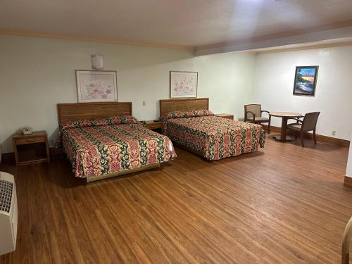 罗斯米德Plaza Inn Motel - Los Angeles area的酒店客房设有两张床和一张桌子。