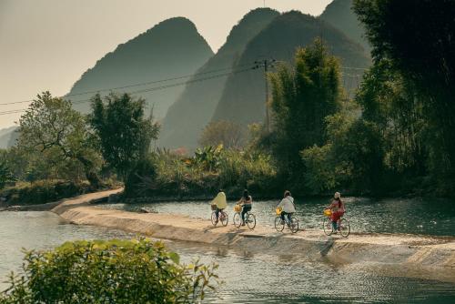 阳朔阳朔云舞度假酒店的一群人骑着自行车沿着河骑行