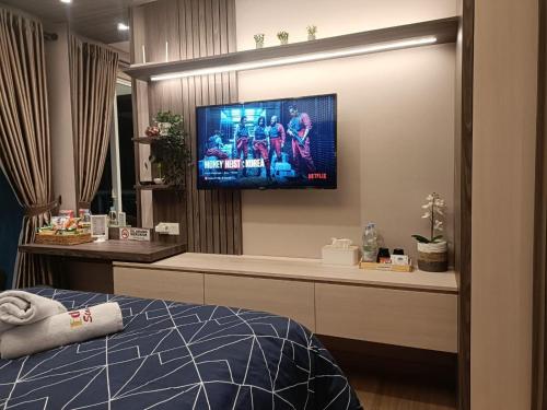 雅加达Luxury Puri Mansion Apartment Kembangan的卧室配有壁挂式平面电视