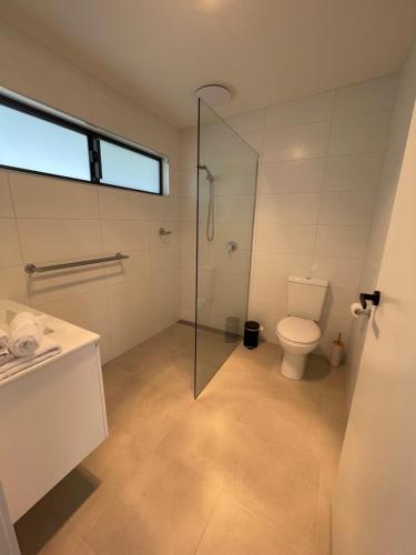 因沃洛什Inverloch Motel的一间带卫生间和玻璃淋浴间的浴室