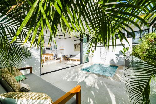 塔马林多Tamarindo Luxury with Beach Club Access的棕榈树房子里的一个房间,设有游泳池