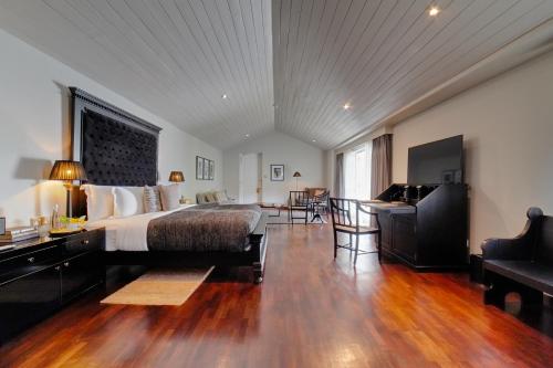康提W15 Hanthana Estate Kandy的酒店客房配有一张床、一张书桌和一张沙发。