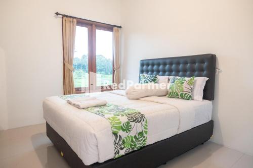 日惹Twin House near UII Yogyakarta Mitra RedDoorz的一间卧室设有一张大床和窗户