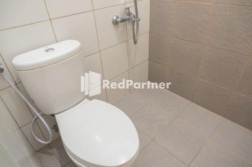 日惹Twin House near UII Yogyakarta Mitra RedDoorz的浴室配有白色卫生间和淋浴。