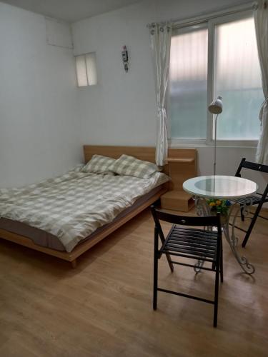 仁川市Jemulpo house - Foreigner Only的卧室配有1张床、1张桌子和1把椅子