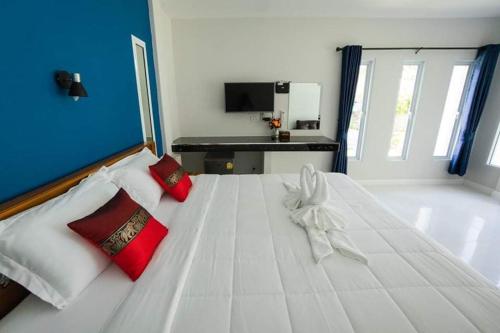 班邦宝Coco Sea Bangpo Resort的一张大白色的床,配有红色枕头