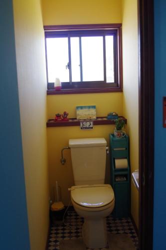 宫崎Finecamp Guesthouse Share Room 相部屋的一间带白色卫生间的浴室和窗户。