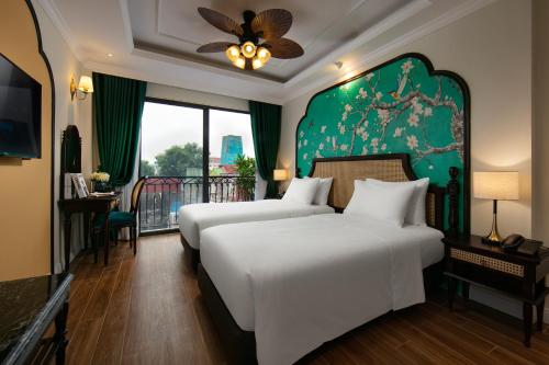 河内La Passion Hanoi Hotel & Apartment的一间卧室设有两张床和绿色的墙壁