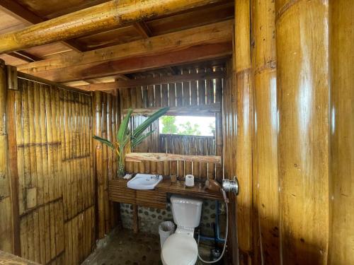 巴顿港Jungle bar Resto & Cottages的木屋内的浴室设有卫生间